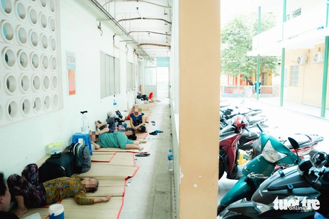 Nhiều người dân trải chiếu nằm trú nóng trên hành lang của BV Nguyễn Trãi - Ảnh: THANH HIỆP Nhiều người trải chiếu nằm tránh nắng ngay hành lang Bệnh viện Nguyễn Trãi (TP.HCM) - Ảnh: THANH HIỆP