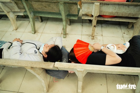 Thân nhân chăm bệnh Người chăm bệnh nằm trên những chiếc ghế đá dưới các mái che của Bệnh viện Nguyễn Tri Phương để tránh nóng