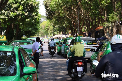 Xe taxi đậu kín đường xung quanh sân bay Tân Sơn Nhất- Ảnh 1. Xe máy luồn lách, di chuyển khó khăn trên đường A75 Bạch Đằng (phường 2, quận Tân Bình), cạnh sân bay Tân Sơn Nhất do đường bị taxi lấn chiếm để đậu xe - Ảnh: NGỌC QUÝ