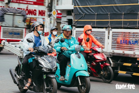Hai anh shipper chạy song song nói chuyện với nhau khi tham gia lưu thông - Ảnh: THANH HIỆP Shipper vừa chạy song song vừa nói chuyện với nhau - Ảnh: THANH HIỆP