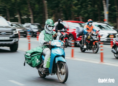 Nhiều tài xế công nghệ điều khiển giao thông nhưng mắt lại dán vào điện thoại - Ảnh: THANH HIỆP Nhiều tài xế công nghệ chạy xe nhưng mắt lại dán vào điện thoại - Ảnh: THANH HIỆP