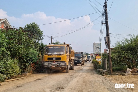 Đường làng thành đường công vụ, dân chặn xe thi công cao tốc vì gây bụi, mất an toàn- Ảnh 1. Hàng loạt xe tải lớn bị người dân chặn lại trên đường làng Vĩnh An - Ảnh: HOÀNG TÁO