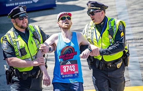 Đừng để các giải chạy bộ bát nháo- Ảnh 7. Một VĐV tham dự Boston Marathon hôm 15-4 được cảnh sát giúp đỡ khi về đích - Ảnh: Getty