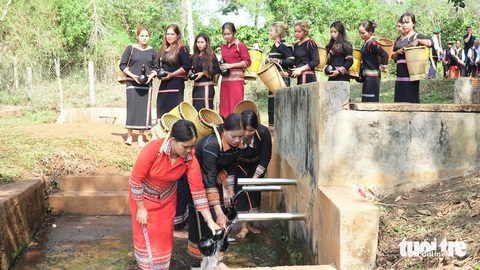 Xem người Ba Na tái hiện lễ cầu mưa giữa mùa khô Tây Nguyên- Ảnh 1. Nghi thức lấy nước vào bầu khô với mong muốn nguồn nước luôn dồi dào, tuôn chảy - Ảnh: BỒNG SƠN