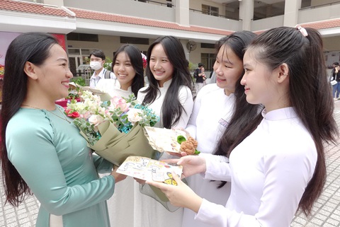 Học sinh Trường THPT Nguyễn Hữu Thọ, quận 4, TP.HCM tặng hoa cô giáo chúc mừng Ngày Nhà giáo Việt Nam - Ảnh: NHƯ HÙNG Tin tức sáng 16-8: Bộ Chính trị yêu cầu lương nhà giáo được ưu tiên xếp cao nhất- Ảnh 1.