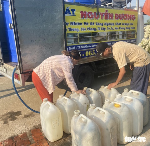Nhiều đoàn từ thiện chở nước ngọt cho bà con vùng hạn mặn- Ảnh 4. Đoàn từ thiện thị xã Tân Châu, An Giang bơm nước vào can nhựa cho bà con huyện Giang Thành