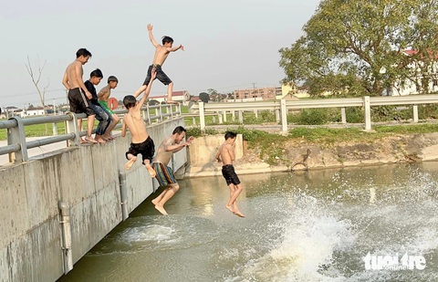 Đổ mồ hôi mưu sinh giữa nắng nóng 40 độ C- Ảnh 9. Mỗi buổi chiều, trẻ em lại ra kênh ở huyện Yên Thành, Nghệ An tắm giải nhiệt - Ảnh: DOÃN HÒA