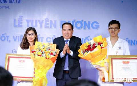 Vinh danh vợ chồng bác sĩ cấp cứu nạn nhân vụ xe chở đoàn Cục Quản lý thị trường- Ảnh 1. Ông Phạm Thế Đồng - phó chủ tịch thường trực Hiệp hội Bệnh viện tư nhân Việt Nam - trao bằng khen của hiệp hội cho vợ chồng bác sĩ Lương Hải Yến và Nguyễn Văn Giáp - Ảnh: TẤN LỰC