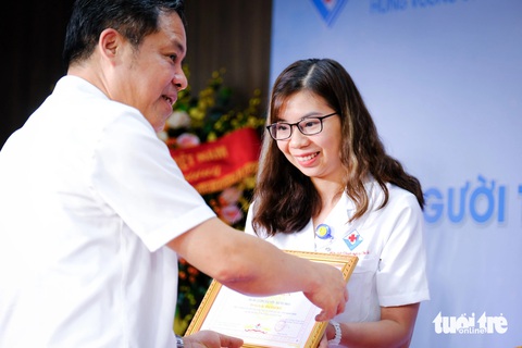 Vinh danh vợ chồng bác sĩ cấp cứu nạn nhân vụ xe chở đoàn Cục Quản lý thị trường- Ảnh 3. Ông Phạm Văn Học - tổng giám đốc Bệnh viện Hùng Vương Gia Lai - trao giấy khen cho bác sĩ Lương Hải Yến - Ảnh: TẤN LỰC
