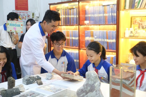 Học sinh TP.HCM thích thú tìm hiểu hóa thạch trăm triệu năm tuổi- Ảnh 1. Các em học sinh Trường THCS Huỳnh Khương Ninh (quận 1, TP.HCM) thích thú sờ vào các mẫu hóa thạch trăm triệu năm tuổi - Ảnh: NGỌC PHƯỢNG
