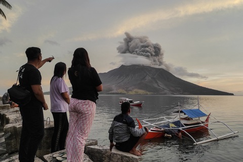 Núi lửa Indonesia phun cột tro bụi 250m khiến 11.000 người sơ tán- Ảnh 1. Người dân nhìn vào núi lửa Ruang trên đảo Tagulandang ở Sitaro, Bắc Sulawesi hôm 19-4. Ngọn núi lửa này tiếp tục phun trào chiều 20-4 - Ảnh: AFP