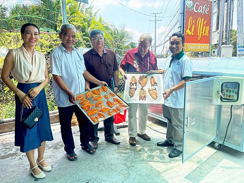 Giảng viên làm máy sấy đa năng, tiết kiệm điện bán ra cả nước- Ảnh 1. Thầy Phan Văn Hiệp (bìa phải) với thành phẩm cá điêu hồng sấy khô - Ảnh: NVCC