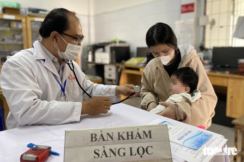 TP.HCM nhận 13.000 liều vắc xin 5 trong 1, sẵn sàng tiêm cho trẻ- Ảnh 1. Khám sàng lọc cho trẻ trước khi tiêm vắc xin 5 trong 1 tại Trạm y tế xã Phú Xuân, huyện Nhà Bè (TP.HCM) - Ảnh: XUÂN MAI