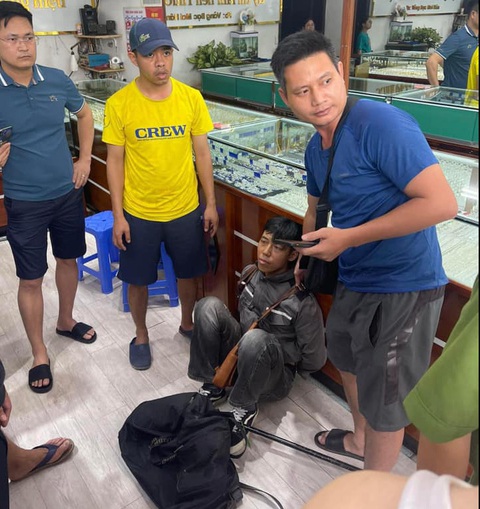 Bắt tại trận thanh niên cướp tiệm vàng ở Phú Thọ- Ảnh 1. Tên cướp tiệm vàng Đinh Quang Minh (áo đen, ngồi) bị bắt tại trận - Ảnh: QUANG SƠN