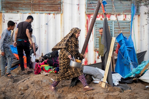 Một người phụ nữ bước đi khi những người Palestine khác kiểm tra địa điểm xảy ra cuộc tấn công của Israel ở Rafah, phía nam Dải Gazangày 22-4 - Ảnh: REUTERS Một người phụ nữ bước đi khi những người Palestine khác kiểm tra địa điểm xảy ra cuộc tấn công của Israel ở Rafah, phía nam Dải Gaza, ngày 22-4 - Ảnh: REUTERS