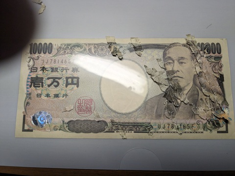 Dành ba tuần để ghép hàng ngàn mảnh vụn thành tờ 10.000 yen- Ảnh 3. Cậu bé sử dụng một tờ 10.000 yen nguyên vẹn để đối chiếu từng mảnh vụn.