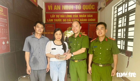 Người phụ nữ nhận lại 400 triệu đồng chuyển nhầm- Ảnh 1. Bà Thấm nhận lại 400 triệu đồng do chuyển nhầm tài khoản ngân hàng - Ảnh: Công an cung cấp