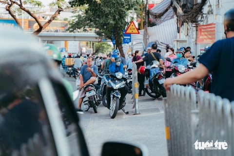 Nhiều phụ huynh đậu xe dưới đường hút thuốc chờ đợi con tan học - Ảnh: THANH HIỆP Nhiều phụ huynh đậu xe dưới đường hút thuốc chờ đón con tan học - Ảnh: THANH HIỆP