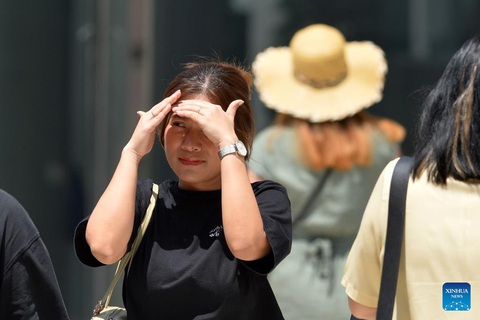 Một người đi bộ che mặt khỏi nắng ở Bangkok, Thái Lan - Ảnh: Xinhua Một người đi bộ lấy tay che nắng khi đi ở Bangkok, Thái Lan - Ảnh: Xinhua