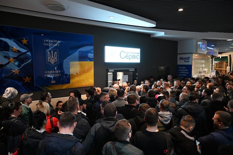 Phản ứng của nam giới Ukraine ở Ba Lan trước quy định buộc hồi hương đi lính- Ảnh 1. Nhiều người Ukraine tụ tập trước văn phòng cấp hộ chiếu Ukraine đã đóng cửa, trong ảnh chụp tại trung tâm mua sắm ở Warsaw, Ba Lan hôm 24-4 - Ảnh: AFP