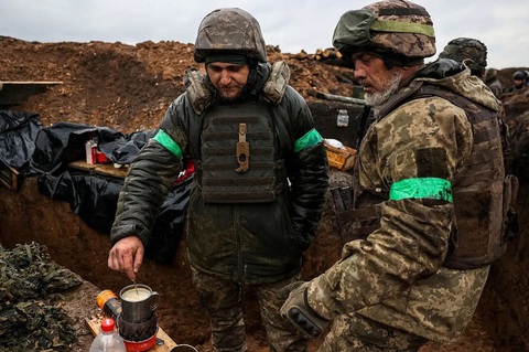 Tìm hoa dọc chiến hào ở Gaza, Ukraine- Ảnh 1. Binh sĩ Ukraine pha cà phê ngay giữa chiến hào - Ảnh: AFP
