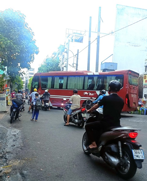 Bến xe mọc sát trường học, chẳng lẽ bó tay?- Ảnh 1. Phụ huynh, học sinh đi lại khó khăn vì xe khách án ngữ giữa đường (ảnh chụp sáng 26-4) - Ảnh: M.TR.