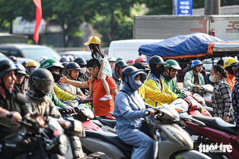 Người dân đội nắng rời Hà Nội về nghỉ lễ, càng về tối càng ùn tắc- Ảnh 10. Người đi bộ vất vả len qua dòng xe kẹt cứng để sang đường - Ảnh: HỒNG QUANG