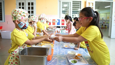 Bạo hành trẻ trong giờ ăn: Giáo viên bị áp lực vì phụ huynh muốn con ăn giỏi, tăng cân?- Ảnh 3. Học sinh lớp lá 4 Trường mầm non Sơn Ca 3, phường Hiệp Bình Chánh, TP Thủ Đức (TP.HCM) mặc tạp dề, múc cơm, canh cho các bạn - Ảnh: PHƯƠNG QUYÊN