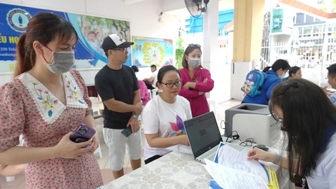 TP.HCM: Tuyển sinh đầu cấp mầm non, lớp 1 theo nơi ở sao cho suôn sẻ?- Ảnh 1. Phụ huynh đến nộp hồ sơ tuyển sinh vào lớp 1 năm học 2023 - 2024 tại một trường tiểu học ở TP.HCM - Ảnh: NHƯ HÙNG