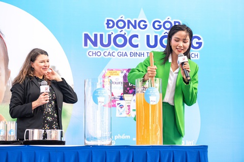 P&G Việt Nam cùng Saigon Co.op tiếp tục hợp tác mang nước uống sạch đến cộng đồng- Ảnh 3. Hoa hậu H Hen Nie thực hiện các bước lọc nước sau khi hòa tan gói lọc nước của P&G