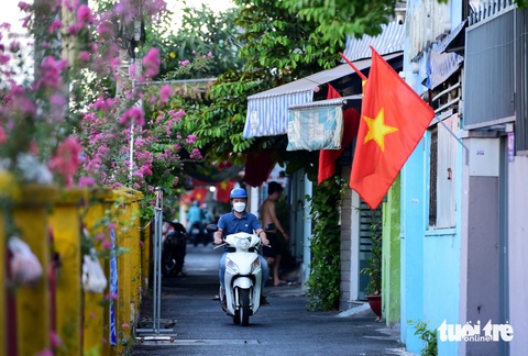 TP.HCM trong lành, cờ đỏ rợp phố ngày đầu nghỉ lễ- Ảnh 4. Những con đường chạy dọc đường ray xe lửa, cờ và hoa hòa vào nhau tạo nên một khung cảnh tuyệt đẹp
