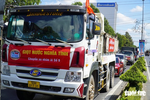 Đi lại ngày đầu nghỉ lễ 30-4: Cao tốc TP.HCM - Long Thành - Dầu Giây dễ thở- Ảnh 10. Trong dòng xe chờ qua cầu Rạch Miễu, có nhiều đoàn xe chở nước ngọt về vùng hạn mặn Bến Tre - Ảnh: MẬU TRƯỜNG