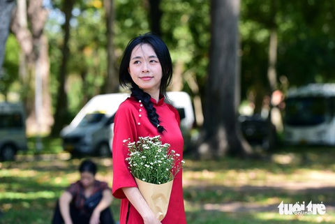 Giới trẻ thưởng thức cà phê bệt, tránh nóng ở công viên- Ảnh 9. Bạn Diệu Vy diện áo dài đỏ để chụp ảnh kỷ niệm