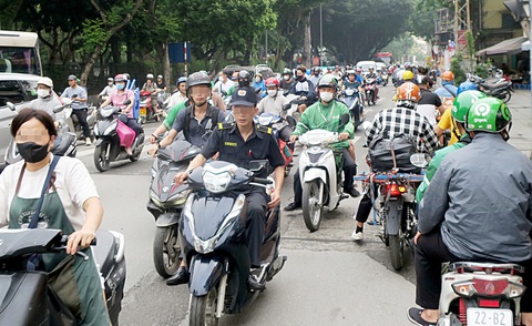 Phạt nguội lái xe máy là bước đầu, căn cơ vẫn là văn hóa giao thông- Ảnh 1. Lái xe máy không đội mũ bảo hiểm, vượt đèn đỏ, chạy ngược chiều sẽ bị phạt nguội. Trong ảnh: giao thông rối loạn góc phố Quốc Tử Giám, Hà Nội sáng 24-4 - Ảnh: T.T.D.
