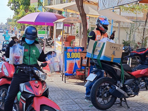 Hãng treo thưởng dịp 30-4 nhưng điều kiện khắt khe, nhiều tài xế tắt app tránh nóng- Ảnh 1. Tài xế giao đồ ăn, trùm kín mít để tránh sốc nhiệt do thời tiết nắng nóng trong những ngày đầu kỳ nghỉ lễ 30-4 - Ảnh: CÔNG TRUNG