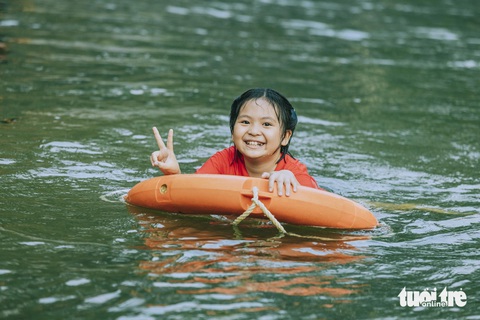 Nắng nóng đỉnh điểm, người dân Nghệ An đổ ra sông, suối- Ảnh 6. Một em nhỏ thích thú khi được bố mẹ cho học bơi vừa tắm mát trong kỳ nghỉ lễ - Ảnh: RẠNG ĐÔNG