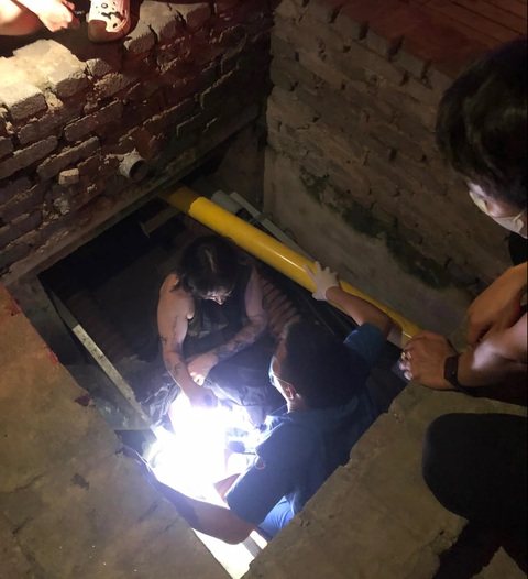 Đi bộ trên vỉa hè, cô gái người Anh ngã xuống hố thi công cáp ngầm ở Hà Nội- Ảnh 1. Cô gái ngã xuống hố được công an tìm cách đưa lên - Ảnh: Công an cung cấp