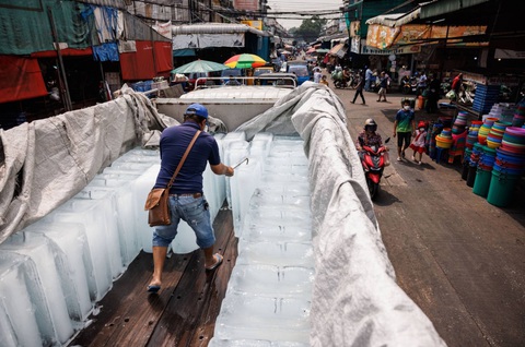 El Nino hay biến đổi khí hậu gây nắng nóng thiêu đốt ở châu Á?- Ảnh 2. Một tiểu thương xử lý khối đá dưới thời tiết nóng như thiêu đốt ngày 27-4 tại một khu chợ ở Thái Lan - Ảnh: BLOOMBERG