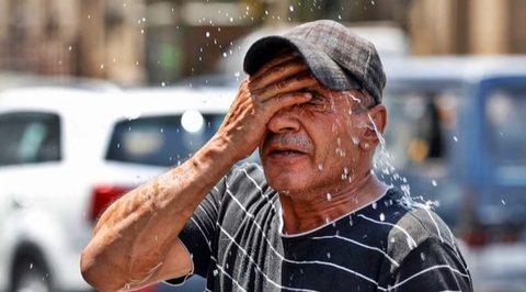 El Nino hay biến đổi khí hậu gây nắng nóng thiêu đốt ở châu Á?- Ảnh 5. Một người đàn ông tự dội nước vào mặt trong đợt nắng nóng vừa qua tại Ấn Độ - Ảnh: AFP