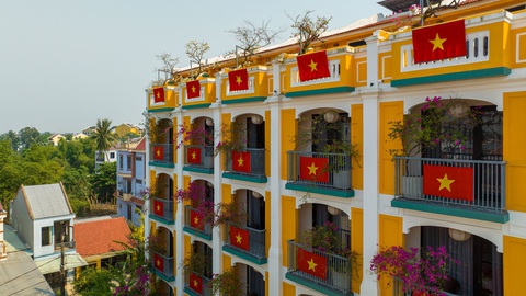 Một khách sạn ở Hội An đỏ rực ấn tượng với 80 lá cờ Tổ quốc- Ảnh 3. Cờ Tổ quốc treo ở các ban công tạo hình ảnh đặc biệt trong ngày thống nhất - Ảnh: Q.N.