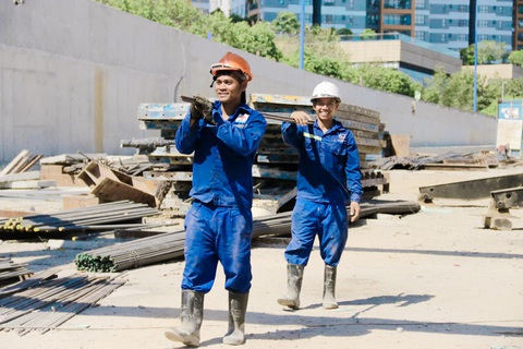 Nhiều công trình giao thông trọng điểm ở TP.HCM làm xuyên lễ- Ảnh 12. Nút giao An Phú (TP Thủ Đức) là công trình trọng điểm của TP.HCM. Ghi nhận tại công trường nút giao sáng 29-4, giữa cái nắng oi bức, tiếng máy móc, tiếng cười nói của công nhân vẫn rộn vang. Trong ảnh: hai công nhân đang di chuyển sắt, thép tới điểm hàn hoàn thiện các tấm đan rãnh thoát nước tại khu vực thi công gói thầu XL5 - Ảnh: TIẾN QUỐC