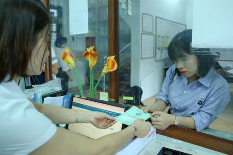 Tin tức sáng 4-4: Tốc độ tăng giá chung cư Hà Nội vượt TP.HCM; Hơn 90 triệu người Việt có thẻ BHYT- Ảnh 1. Cán bộ bảo hiểm xã hội trả sổ cho người lao động sau khi kiểm tra thông tin - Ảnh: HÀ QUÂN
