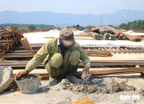 Công nhân 'vượt nắng' thi công dự án cao tốc Bắc - Nam- Ảnh 6. Anh Ngô Văn Thuấn - chỉ huy phó công trình thi công của Tổng công ty 319 - cho biết đơn vị thi công gói thầu phân đoạn từ Km 501+470 đến đoạn Km 514+479 thuộc dự án thành phần Bãi Vọt - Hàm Nghi. Sau 14 tháng thi công, đơn vị tập trung vào phần nền đường, đất đắp, hoàn thiện hệ thống thoát nước và công trình cầu vượt tuyến. Đến nay khối lượng công việc đạt hơn 30% so với giá trị hợp đồng. Trong ảnh: Một công nhân làm việc tại dự án - Ảnh: LÊ MINH