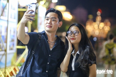 Người dân đổ về trung tâm TP.HCM ngắm pháo hoa- Ảnh 2. Từ Đắk Lắk vào TP.HCM chơi lễ, Hiệp và Khánh Ly hào hứng với không khí sôi động, náo nhiệt trước giờ bắn pháo hoa - Ảnh: PHƯƠNG QUYÊN