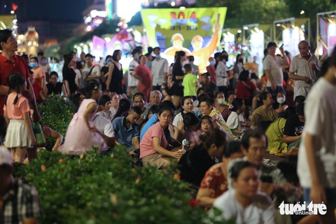 Người dân đổ về trung tâm TP.HCM ngắm pháo hoa- Ảnh 4. Người dân mang theo thảm trải, thức ăn ngồi dọc phố đi bộ - Ảnh: PHƯƠNG QUYÊN
