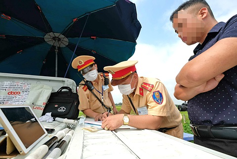 Trừ điểm bằng lái người vi phạm, cũng nên cộng điểm cho 'camera chạy bằng cơm'- Ảnh 1. Lực lượng giao thông kiểm tra nồng độ cồn người lái xe - Ảnh: NAM TRẦN