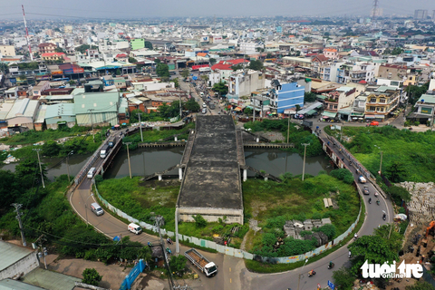 Chủ tịch TP.HCM tuyên dương 6 quận giải ngân đầu tư công, Bình Tân vượt trội với 32%- Ảnh 1. Cầu Tân Kỳ - Tân Quý (phường Bình Hưng Hòa, quận Bình Tân) đã hoàn thành phần giữa cầu bắc qua kênh Tham Lương, hai bên là cầu tạm bằng sắt để người dân đi lại - Ảnh: PHƯƠNG NHI