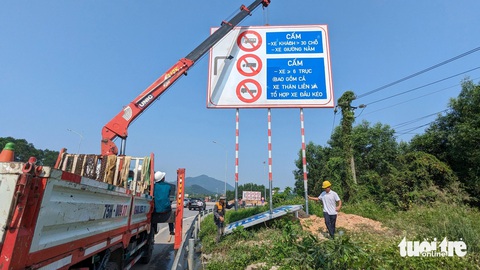 Ngày đầu cấm xe tải nặng trên cao tốc Cam Lộ - La Sơn: Xe quay đầu, xe vẫn lưu thông- Ảnh 3. Ban quản lý đường Hồ Chí Minh cắm biển báo cấm một số loại xe tại nút Cầu Tuần dẫn lên cao tốc Cam Lộ - La Sơn - Ảnh: NHẬT LINH