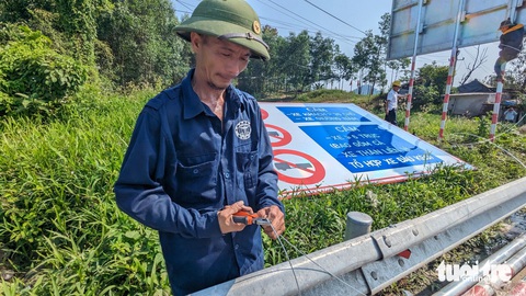 Ngày đầu cấm xe tải nặng trên cao tốc Cam Lộ - La Sơn: Xe quay đầu, xe vẫn lưu thông- Ảnh 6. Nhân công tích cực lắp đặt, hoàn thiện biển báo - Ảnh: NHẬT LINH