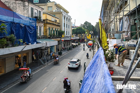 Bắt đầu 'đại tu' mặt tiền tuyến phố đắt đỏ bậc nhất Hà Nội- Ảnh 2. Các tòa nhà dọc dãy từ nút giao với Đinh Tiên Hoàng đến đoạn giao Nguyễn Xí được quây kín tầng 2 để thi công - Ảnh: HỒNG QUANG